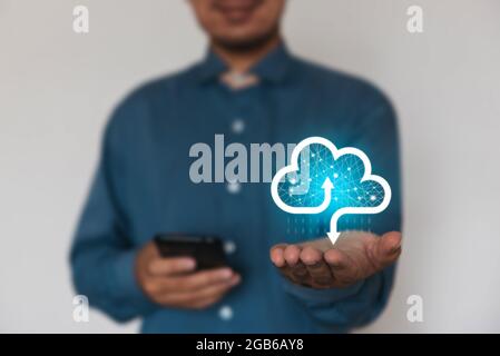 Homme d'affaires tenant une icône de données de nuage avec la lumière et l'icône multimédia application icon.Computing données sur le réseau. Assurance Business Computer Securit Banque D'Images