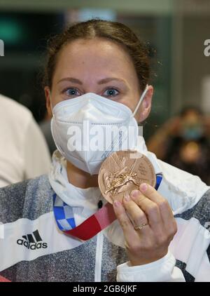 02 août 2021, Hessen, Francfort-sur-le-main : Sarah Köhler de Francfort se tient à l'aéroport de Francfort avec sa médaille de bronze après son arrivée de Tokyo. Elle avait terminé troisième dans la nage libre de 1,500 aux Jeux olympiques. Photo: Frank Rumpenhorst/dpa Banque D'Images