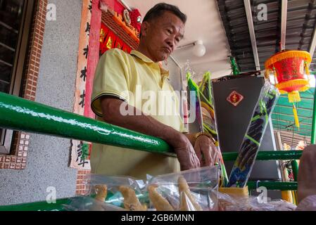 Un commerçant dans un village en Chine trie ses marchandises prêtes à la vente Banque D'Images