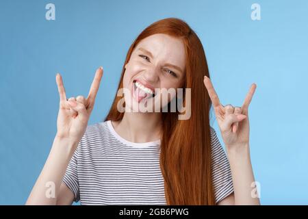 Oser insouciance ludique excitée bonne-regardant drôle redhead fille ayant le plaisir montrez l'affaissement de la languette faites de la grimace ravie faire du métal lourd rock-n-roll signe Banque D'Images