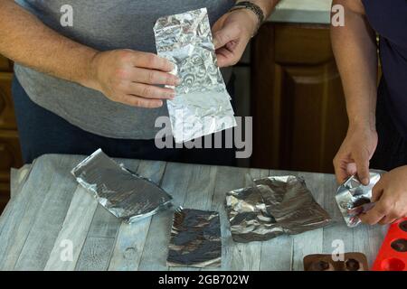 Processus étape par étape de fabrication de chocolats à partir de chocolat noir et de cerises au cognac à la maison. Chaque bonbon est retiré du moule en silicone et emballé Banque D'Images