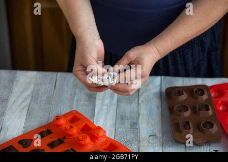 Processus étape par étape de fabrication de chocolats à partir de chocolat noir et de cerises au cognac à la maison. Chaque bonbon est retiré du moule en silicone et emballé Banque D'Images