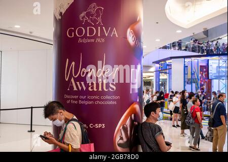 Hong Kong, Chine. 02 août 2021. Les acheteurs se tiennent à côté d'une publicité commerciale du fabricant et de la marque multinationale belge Godiva à Hong Kong. (Photo de Budrul Chukrut/SOPA Images/Sipa USA) crédit: SIPA USA/Alay Live News Banque D'Images