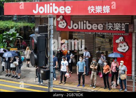 Hong Kong, Chine. 02 août 2021. On voit des piétons attendre au feu de circulation devant la chaîne multinationale philippine de restauration rapide Jollibee restaurant à Hong Kong. (Photo de Budrul Chukrut/SOPA Images/Sipa USA) crédit: SIPA USA/Alay Live News Banque D'Images