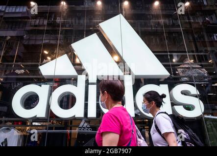 Hong Kong, Chine. 02 août 2021. Des piétons marchent devant la marque allemande multinationale de vêtements de sport Adidas magasin et logo à Hong Kong. (Photo de Budrul Chukrut/SOPA Images/Sipa USA) crédit: SIPA USA/Alay Live News Banque D'Images