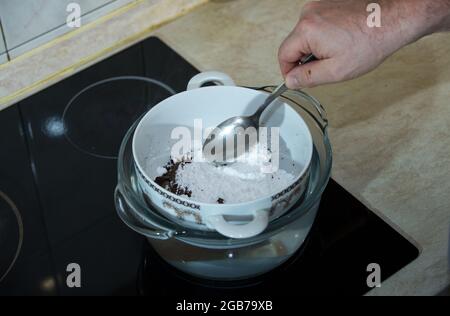 Processus étape par étape de fabrication de chocolats à partir de chocolat noir et de cerises au cognac à la maison. Processus de fusion des ingrédients pour le chocolat Banque D'Images