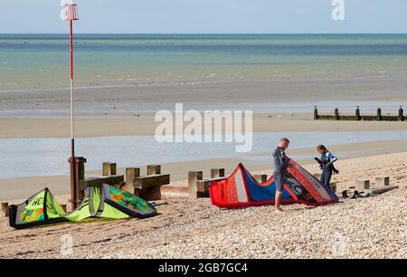 Bognor Regis, Royaume-Uni. 29 juillet 2021. Vicky a été kitesurf pendant plus d'un an et fait vraiment bien. Aujourd'hui, elle a une leçon de surf avancée et est vue sur un harnais tandis que son professeur Andy prépare les feuilles d'aile sur la plage. Crédit: Joe Kuis / reportage Alay Banque D'Images