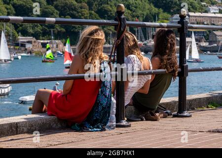 Trois femelles se détendant sur le Quayside - Fowey, Cornwall, Royaume-Uni. Banque D'Images