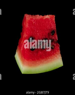 Morceau de melon d'eau mûr coupé en tranches sur fond noir Banque D'Images