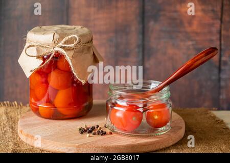 Pot de tomates fermentées sur fond de bois. Conserves maison. Banque D'Images