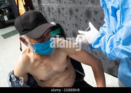 Bogota, Colombie. 2 août 2021. Un homme reçoit une dose du vaccin Moderna COVID-19 alors que les conducteurs de transport public et les personnes de 25 à 30 ans commencent leur phase de vaccination avec le nouveau vaccin Moderna COVID-19 contre la coronavirus à Bogota, Colombie, le 2 août 2021. Crédit : long Visual Press/Alamy Live News Banque D'Images