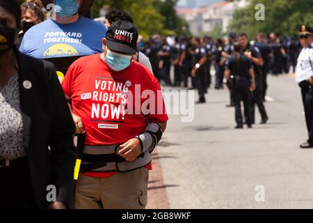 Washington, DC, Etats-Unis, 2 août 2021. Photo : le maillot d'un manifestant demande la préservation du droit de vote, tandis que derrière lui, environ 100 officiers de la police du Capitole répondent à un lundi de mars moral d'environ 1000 manifestants pacifiques. Ils en ont arrêté des centaines pour avoir bloqué une rue devant le bâtiment Hart Senate. Cela a continué la réaction excessive du département face aux événements « de gauche », en contraste frappant avec ses réponses aux événements d'extrême droite. La campagne des pauvres, le Centre Kairos et les réparateurs de la violation ont parrainé la marche. Crédit : Allison Bailey / Alamy Live News Banque D'Images