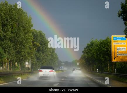 Potsdam, Allemagne. 1er août 2021. Les voitures circulent dans l'après-midi sous la pluie sur la Nuthestrasse L 40 près de la sortie Wetzlarer Straße en direction d'un arc-en-ciel. Credit: Soeren Stache/dpa-Zentralbild/ZB/dpa/Alay Live News Banque D'Images