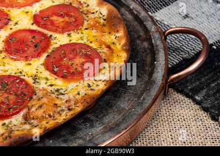 Pizza brésilienne napolitaine avec mozzarella et tranches de tomate avec origan, vue du dessus Banque D'Images