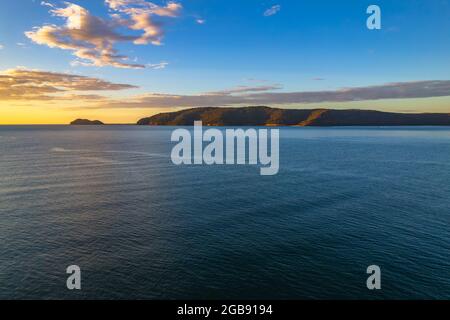 Bateaux de pêche et lever du soleil dans la baie de Brisk depuis la plage de Patonga, sur la côte centrale de Nouvelle-Galles du Sud, Australie. Banque D'Images