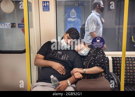 Londres, Royaume-Uni. 23 juillet 2021. Un couple a vu porter des masques faciaux à leur arrivée à la gare de Kings Cross. Malgré la fin de l'obligation légale de porter des masques faciaux en Angleterre, le port de masques faciaux est resté obligatoire sur les transports à Londres et les gens continuent à se conformer à la réglementation. Crédit : SOPA Images Limited/Alamy Live News Banque D'Images