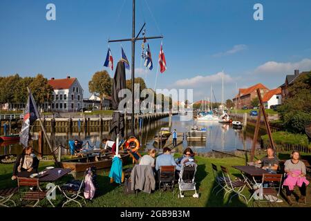 Personnes dans le jardin de bière de l'ancien chantier naval en face du port historique, Toenning, Frise du Nord, Schleswig-Holstein, Allemagne Banque D'Images