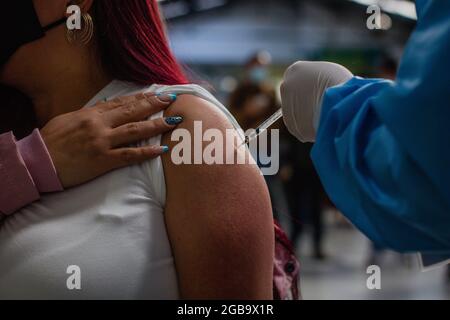 Bogota, Colombie. 2 août 2021. Une femme reçoit une dose du vaccin Moderna COVID-19 alors que les conducteurs de transport public et les personnes de 25 à 30 ans commencent leur phase de vaccination avec le nouveau vaccin Moderna COVID-19 contre la coronavirus à Bogota, Colombie, le 2 août 2021. Crédit : long Visual Press/Alamy Live News Banque D'Images