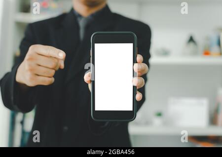 Homme d'affaires tenant un smartphone blanc à écran tactile. Utilisé pour mettre du texte ou de l'information pour annoncer des nouvelles ou vendre des produits en ligne. Concept marketin Banque D'Images