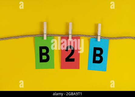 B2B acronyme de Business to Business lettres sur papier coloré attaché à une chaîne avec des crochets en tissu. Banque D'Images