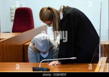 Bonn, Allemagne. 03ème août 2021. Le défendeur de 22 ans siège dans la salle d'audience avant le début du procès et parle à l'avocat Nadine Krahé. La fille de 22 ans de la victime et son amie de 15 ans auraient étouffé l'enfant de 48 ans gravement malade avec un oreiller, car on dit qu'elle n'aurait pas permis à la jeune fille de passer la nuit dans son appartement. Credit: Federico Gambarini/dpa/Alay Live News Banque D'Images