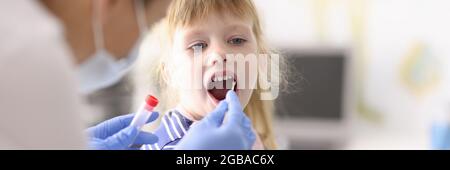 Le médecin prend le matériel biologique de la bouche avec un coton-tige Banque D'Images