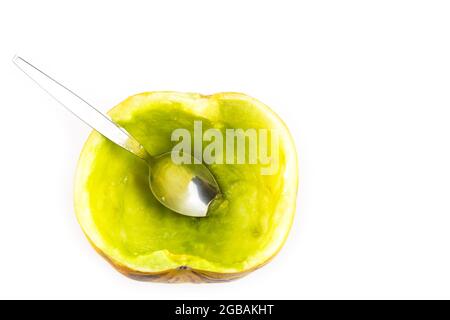 Demi-coupe de melon de cantaloup mûr avec cuillère sur fond blanc Banque D'Images