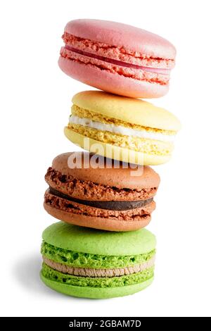 Quatre macarons colorés sur fond rustique en bois blanc. Macarons de petits gâteaux français doux et colorés. Banque D'Images