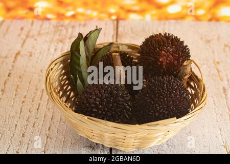 Un petit panier de fruits locaux appelé pulasan, un fruit tropical de la famille des baies de savon, semblable au rambutan. Mise au point sélective. Arrière-plan flou Banque D'Images