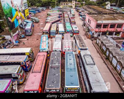 Barishal, Banclairières, 3 août 2021 : vue aérienne entachée d'un drone, d'autobus s'alignent sur le stand de bus de Barishal, l'un des plus achalandés de la région sud du Bangladesh, dans le cadre de la semaine de confinement au Bangladesh, pour tenter d'arrêter la propagation de Covid-19. Crédit: Mustasinur Rahman Alvi / Groupe Eyepix / Alamy Live News Banque D'Images