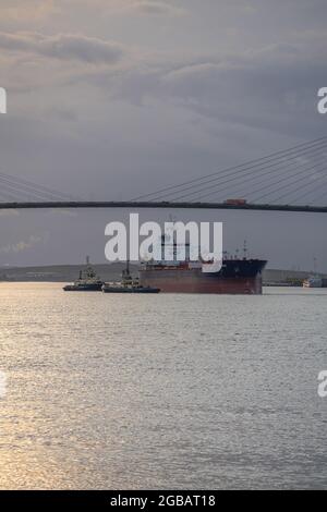 Cargo et remorqueurs sur la Tamise à Thurrock avec le pont de Dartford derrière. Banque D'Images