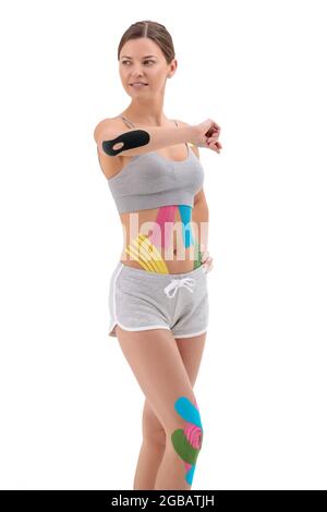Femme montrant des cassettes kinesio sur son corps. Portrait complet de la femme avec des cassettes kinésio médicales lumineuses Banque D'Images