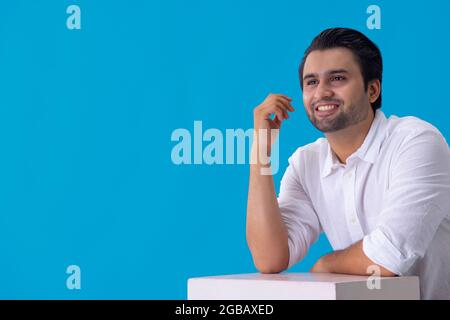 Portrait d'un jeune homme souriant tout en pensant quelque chose. Banque D'Images