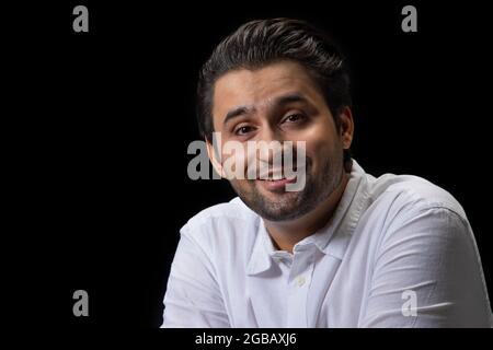 Un portrait d'un jeune homme heureux regardant dans l'appareil photo. Banque D'Images