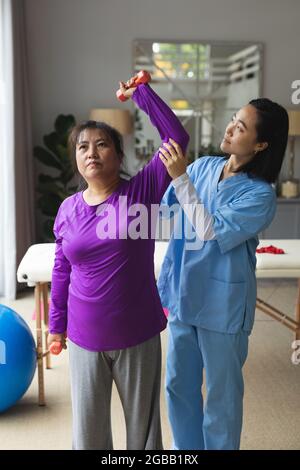 Physiothérapeute asiatique traitant la patiente asiatique chez elle Banque D'Images