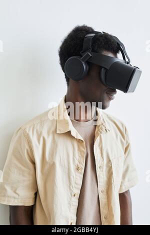 Gros plan du jeune africain en lunettes VR jouant au jeu vidéo sur fond blanc Banque D'Images