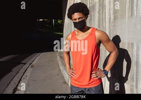 Portrait de l'homme afro-américain FIT s'exerçant en ville en portant un masque facial Banque D'Images