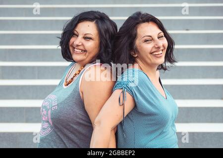 Portrait de deux sœurs jumelles brunette adultes. Différents styles Banque D'Images