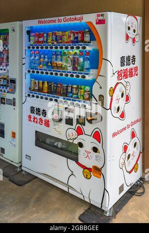 tokyo, japon - mars 02 2021: Distributeur de boissons japonais couvert avec des autocollants publicitaires de Manekineko chats chanceux illustrations dans bouddhiste Got Banque D'Images