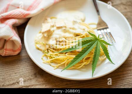 Cannabis nourriture nature herbe concept, Spaghetti carbonara sur l'assiette avec feuille de cannabis - plante de feuilles de marijuana Banque D'Images