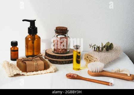 Accessoires de bain et cosmétiques naturels, sel rose himalayan dans un pot en verre, huile essentielle sur fond blanc. Zéro déchet, concept d'aromathérapie. Banque D'Images