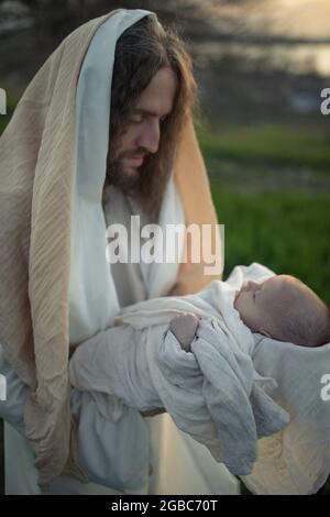 Saint Joseph tient le bébé Jésus dans ses bras et le regarde avec amour. Banque D'Images