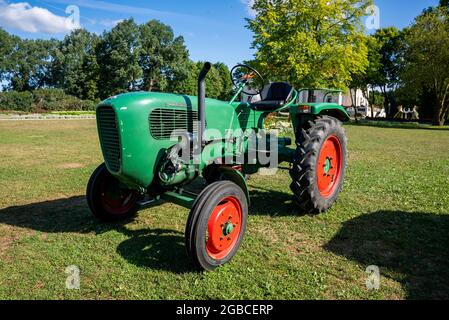 Vieux tracteur dans les prairies alpines dans le jardin. Banque D'Images