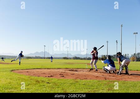 Divers groupes de joueuses de baseball en action sur un terrain de baseball ensoleillé pendant le match Banque D'Images