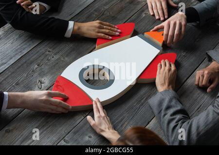 Équipe d'affaires créative assise à table avec une fusée de startup Banque D'Images