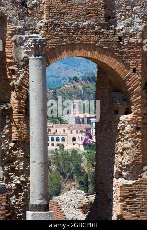 Taormina, Messine, Sicile, Italie. Vue à travers l'arche de la paroi arrière du théâtre grec jusqu'au San Domenico Palace Hotel. Banque D'Images