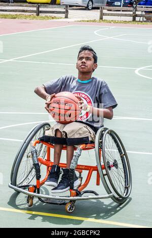 Miami Florida, Tropical Park paralympique expérience, terrain de basket-ball en fauteuil roulant asiatique garçon aime viser paniers de tir, Banque D'Images