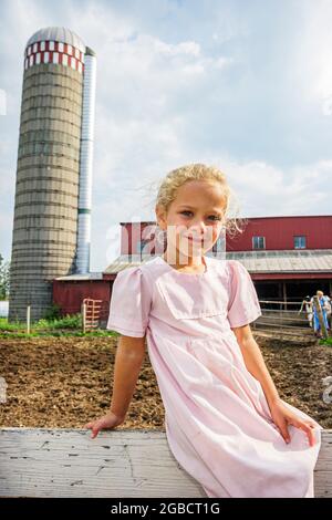 Indiana Shipshewana, Amish Farm Tour, fille enfant assis clôture silo de la grange, Banque D'Images