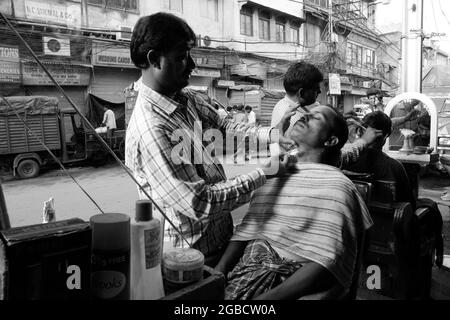 New Delhi, Inde - 13 mars 2016 : un barbier donne un rasage à un client à New delhi, Inde. Il est commun dans toute l'Inde pour les hommes d'obtenir des cheveux Banque D'Images