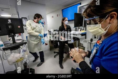 L'infirmière Alix Zacharski, à droite, se désinfecte les mains tandis que d'autres médecins et infirmières continuent de prendre soin d'un patient dans l'unité de soins intensifs médicaux pour les patients COVID-19 à l'hôpital Jackson Memorial le 23 juillet 2021. (Photo de Jose A. Iglesias/Miami Herald/TNS/Sipa USA) Banque D'Images